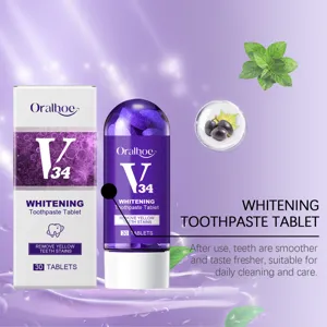 Vue détail de pastilles blanchissantes violettes en flacon avec menthe et raisin en fond.