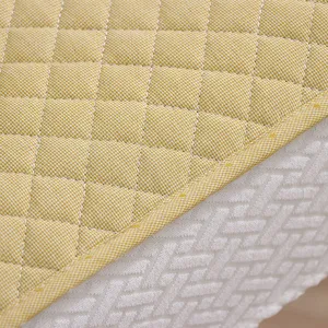 Vue détaillée de housse de chaise matelassée, tissu quadrillé jaune et base texturée.