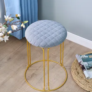 Moderner runder Samthocker mit goldenen Metallbeinen Detailansicht fuer Wohnzimmer Dekoration