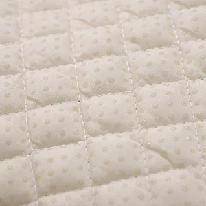 Vue détaillée de tissu de coussin matelassé avec points antidérapants et coutures soignées.