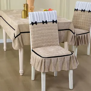 Dining chair cover set with matching tablecloth, quilted beige fabric and elegant black bows.