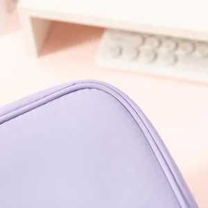 Close-up macro detail showing reinforced corner stitching on a purple waterproof cosmetic bag.