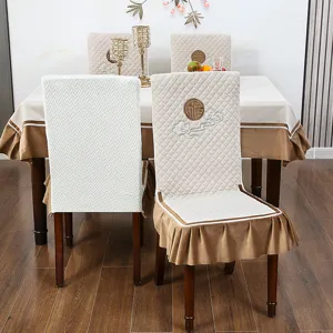 Komplettes Set aus beigen gesteppten Stuhlhussen und passender Tischdecke für Zuhause
