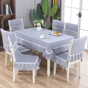 Ensemble de table à manger gris avec nappe et housses de chaise matelassées à bordure dentelle