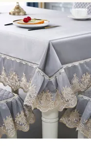 Close-up view of silver embroidered dining chair covers and tablecloth with lace trim