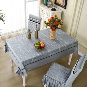 Détail de la nappe à motif marbre gris et de l'ensemble de housses de chaise matelassées