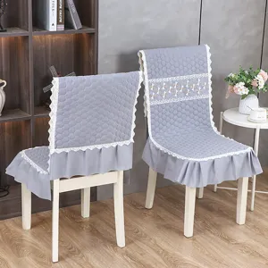 Détail de la housse de chaise matelassée grise avec bordure en dentelle et jupe à volants