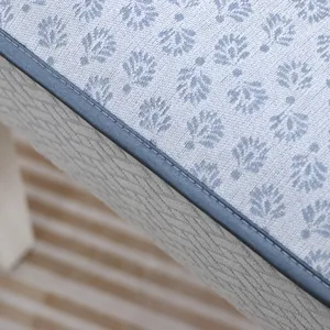 Détail d'un coussin de chaise bleu à motifs avec liseré gris et couture haute qualité