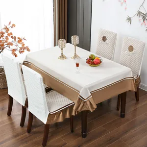 Detail einer luxuriösen beige Tischdecke mit goldenem Satinrand und Stuhlhussen.