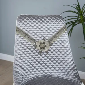Vue détaillée de la housse de chaise matelassée argentée avec dentelle et broderie florale.
