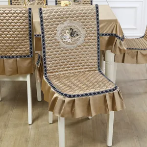 Detail view of champagne gold quilted chair cover with swan embroidery and ruffles