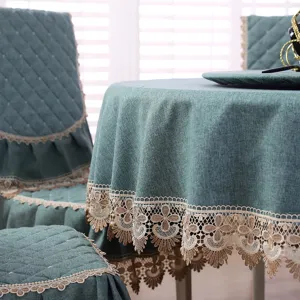 Primo piano di una tovaglia rotonda verde con bordo in pizzo e coprisedie coordinati