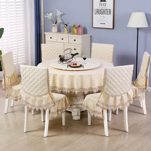Tovaglia rotonda beige e coprisedie trapuntati con pizzo per sala da pranzo