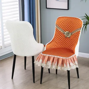 Detail of orange quilted chair cover with lace trim and floral embroidery.