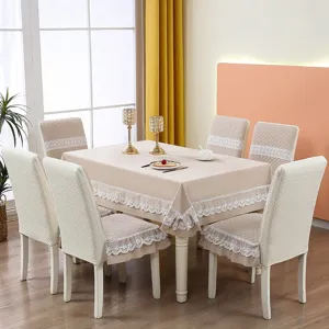 Elegant beige quilted chair cover and matching lace tablecloth set in a dining room