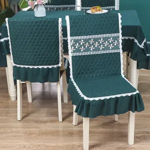 Détails rapprochés de housses de chaise matelassées vert foncé avec dentelle blanche et volant.