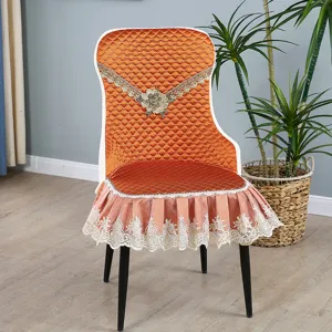 Orange quilted dining chair cover with elegant floral lace trim and ruffled skirt