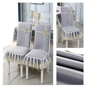Macro detail of gray quilted chair cover fabric with elegant lace trim and floral accents.