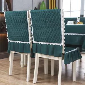 Vue détaillée d'une housse de chaise matelassée vert foncé avec dentelle et volants