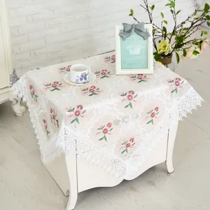 Lace tablecloth detail showing vintage floral embroidery and elegant decorative fringe trim.