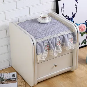 Quilted bedside table dust cover with elegant lace floral trim and soft fabric detail.