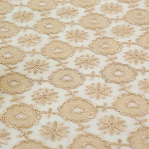 Gold embroidered lace fabric detail close up, elegant floral gauze tablecloth material.