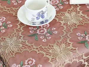 Detailed view of pink mesh lace tablecloth with exquisite gold floral embroidery.