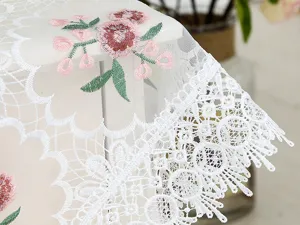 Elegant white lace tablecloth with pink floral embroidery, sheer mesh fabric, home decor.