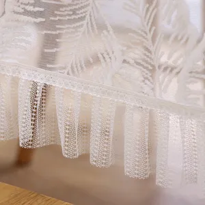 Detalle de mantel de encaje blanco, camino de mesa poliester elegante con volantes.