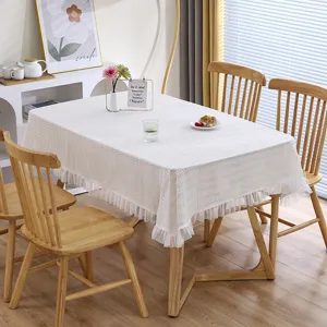 Vista detallada del elegante mantel de encaje blanco con volantes en el comedor acogedor.