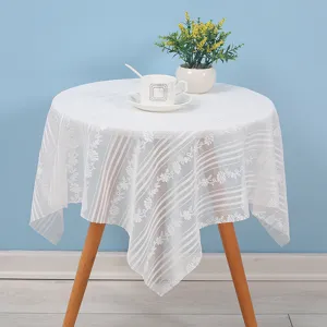 Detail shot of white lace dust cover cloth on table, elegant floral pattern for home decor.