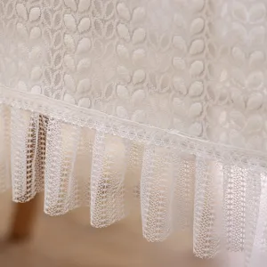 Primer plano de los detalles del mantel de encaje blanco con elegante textura y volantes finos.