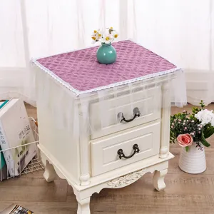 Detalle de funda antipolvo acolchada con elegante borde de encaje blanco para decoración hogar.