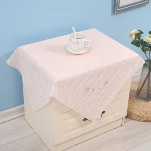 Detailed view of the pink lace dust cover on a bedside table, showcasing delicate floral patterns.