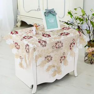 Detailed view of exquisite lace embroidered tablecloth, elegant floral design for home decor.