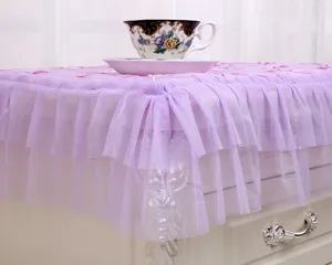Detalle de la funda de encaje púrpura para mesita de noche con volantes plisados y bordados