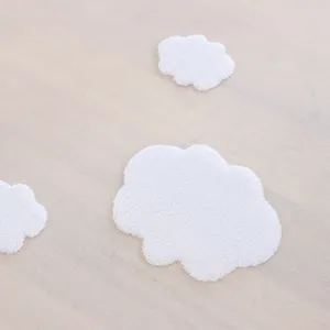 Vista detallada de mantel de encaje estilo princesa con apliques de nubes blancas suaves.