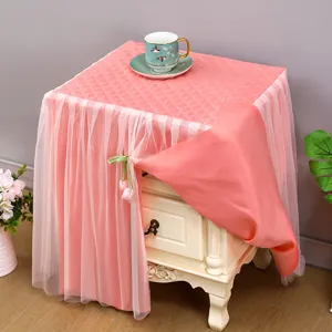 Copertura antipolvere rosa per comodino trapuntata con gonna in pizzo e decoro tulipano.