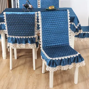 Housse de chaise de salle à manger en velours bleu et nappe avec bordure en dentelle.