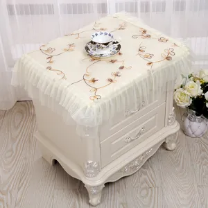 Vista detallada de la cubierta de encaje crema para mesa de noche con bordado floral