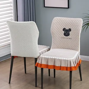 Gros plan sur la housse de chaise de salle à manger matelassée avec dentelle et broderie.