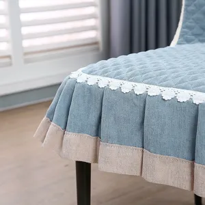 Gros plan détaillé d'une housse de chaise matelassée bleue avec élégante bordure en dentelle.