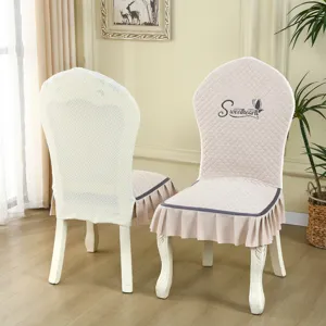 European style elastic chair cover with pleated skirt and quilted design for dining room.