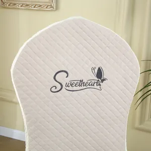 Close up view of beige quilted chair back cover featuring elegant embroidery and butterfly detail.