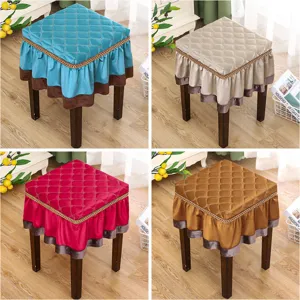 Detailed view of quilted square stool cover with elegant ruffled skirt, perfect for home decor.