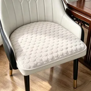 Vue détaillée du coussin de chaise en fer à cheval unicolore avec un motif à pois élégant.
