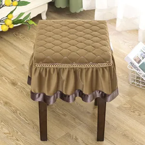 Detailed view of brown quilted square stool cover with elegant ruffle skirt for home decor.