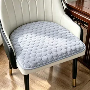 Vue détaillée d'un coussin d'assise gris doux avec motif rond texturé, confortable et élégant.