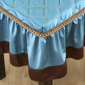 Blue quilted square stool cover detail showing elegant embroidery pattern and decorative gold trim.
