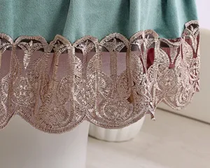 Primer plano detallado de la funda de inodoro de terciopelo verde con ribete dorado.